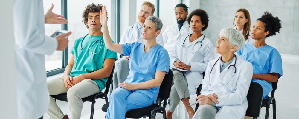 Portrait of a young doctors and nurses in audiance during a seminar in a board room or during an educational class at convention center